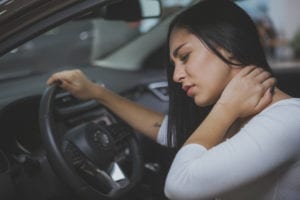 Woman in car with hurt neck