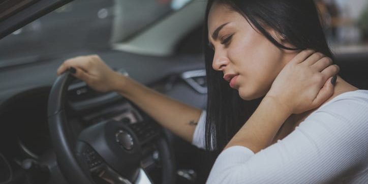 Woman in car with hurt neck