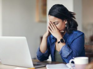 Woman with headache at computer