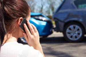 Female driver making phone call after car accident