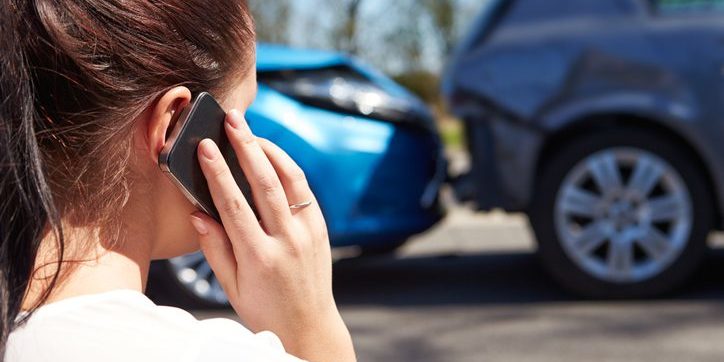 Female driver making phone call after car accident