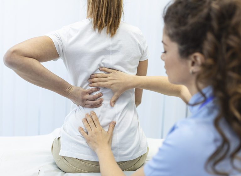 Provider examining a patient’s spine